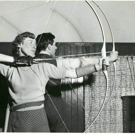 Archery at the Regent Street Polytechnic c.1950 Male and female archer with bows ready to loose their arrows. Black and White Image. | Image courtesy of University of Westminster Archives