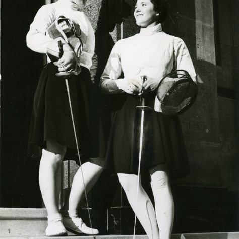 Two women suited up in their fencing attire holding their foils and masks | Image courtesy of University of Westminster Archives