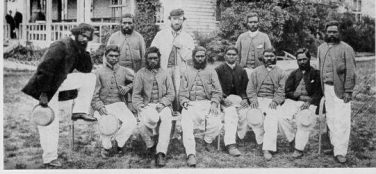 Tom Wills (standing at back wearing a cap) with his aboriginal cricket team in 1866 outside the Melbourne Cricket Ground. | Courtesy of Greg de Moore