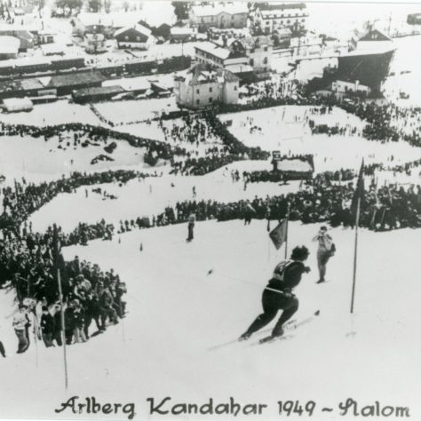 Photograph of Alberg Kandahar_1949 A black and white photo of a skiier doing the Arlberg Kandahar 1949 Slalom with lots of spectators along the slope | DMU Special Collections