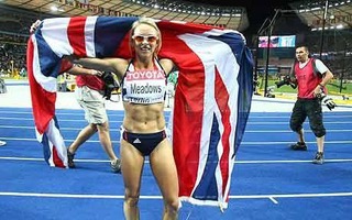 Jenny Meadows wears Union Jack flag around shoulders celebrating on race track