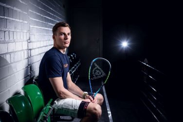 Photo of Nick Matthew sat holding a dunlop racquet