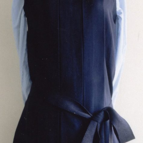 Dark blue dress with a silver brooch over a light blue long sleeve shirt displayed on a mannequin | Bergman Osterberg Union