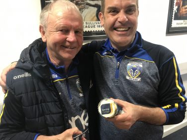 Two representatives of Warrington Wolves pose with a cupcake featuring the Sporting Heritage logo | Warrington Wolves Foundation
