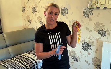 Jenny Meadows holding a medal with a yellow ribbon | Sporting Heritage CIC