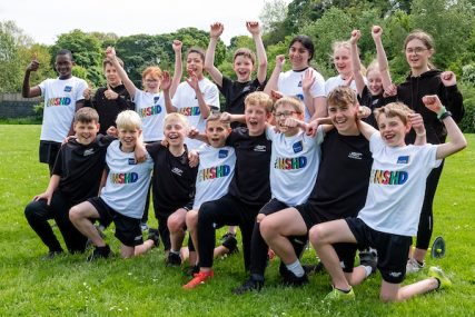 School children cheer whilst wearing NSHD branded tshirts