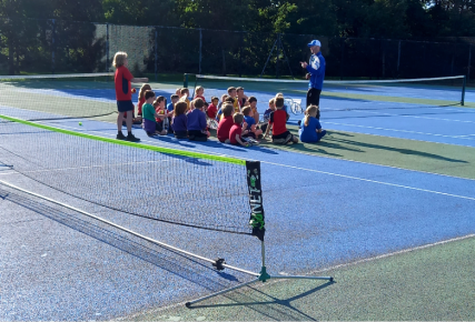 Group of children and coach on tennis courts | Russell Todd