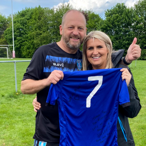 Couple holding signed No7 shirt (Emily Higgins) presented by SWLFC | Courtesy of Dave Higgins
