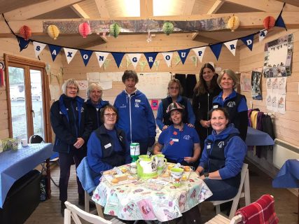 Volunteers sitting around table with tea and cake | Saxon Group RDA
