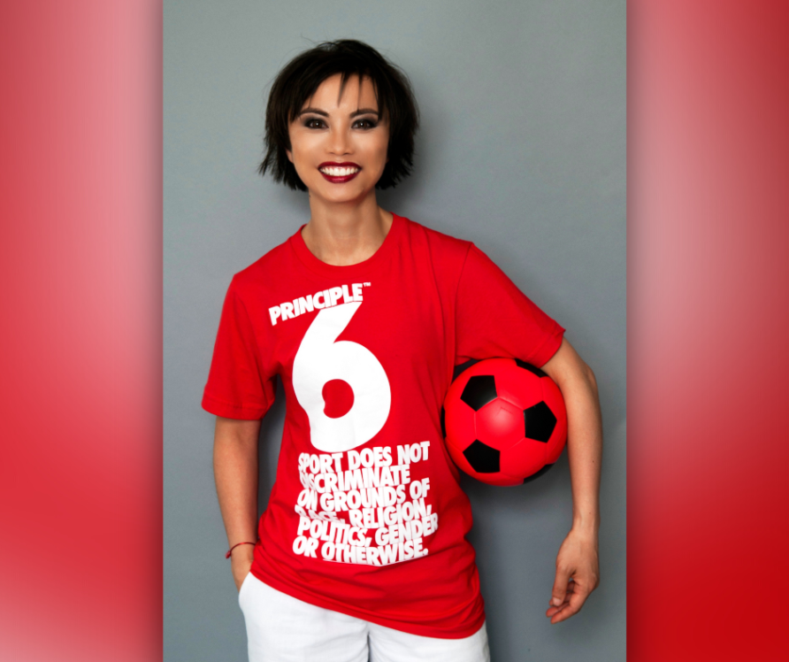 Asian woman with football under arm, wearing a red sport does not descriminate tshirt | Alina Oswald