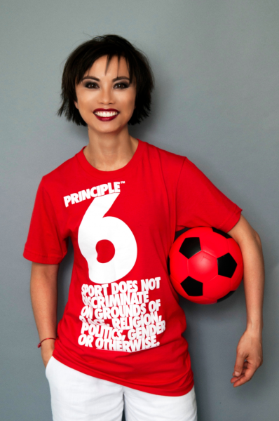 Asian woman with football under arm, wearing a red sport does not descriminate tshirt | Alina Oswald