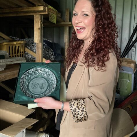 The silverware! Michelle from JFK showing us their trophies. LIHH A woman showing some trophies | Leeds Irish Health & Homes